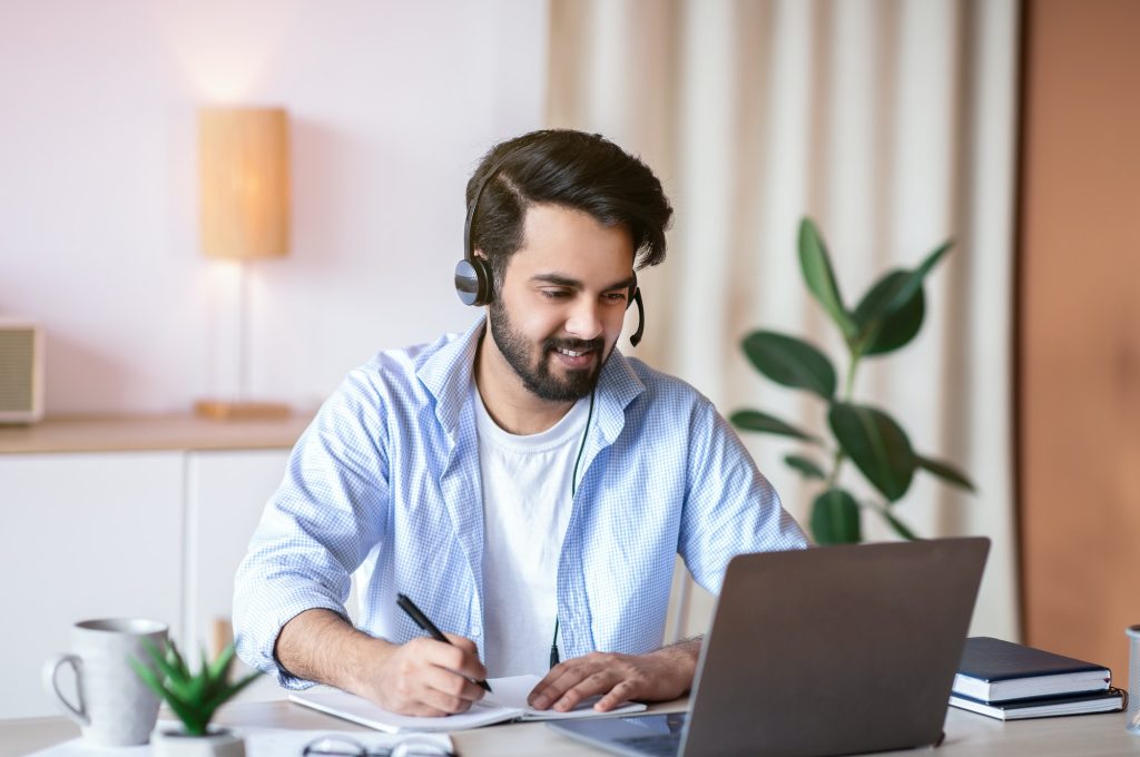 online-education-young-arab-guy-watching-webinar-on-laptop-and-taking-notes.jpg